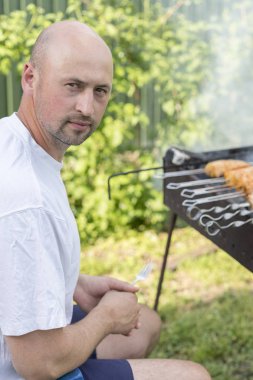 Genç çift kendi bahçesinde barbekü yapma. Dikey fotoğraf.