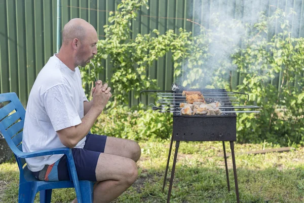 Adam pişirme et mangal üzerinde. Genç çift kendi bahçesinde barbekü yapma. Barbekü üzerinde pişirme et dostum.
