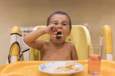 Çocuk 2 yıl yeme. Çocuk tablo. Çocuğun bağımsızlık kavramı. Şirin yürümeye başlayan çocuk ile kaşık yoğurt olduğunu. Çocuk gülümsüyor. komik çocuk çocuk koltuğu
