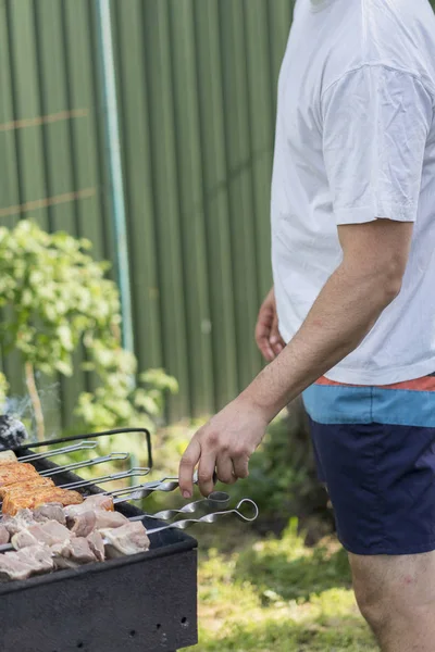 Eğlence, gıda, insanlar ve tatil kavramı - mutlu genç Barbekü Izgara açık yaz parti pişirme et dostum..