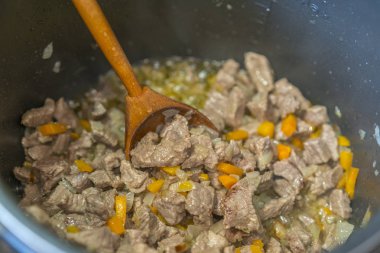 Et Güveç sebze ve otlar. Bir tahta kaşık güveç. Hazırlanması güveç, bir tencerede et.