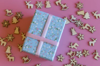 Pembe bir arka plan üzerinde yeni yıl hediyesi. geyik zille ahşap yeni yıl sembolleri kar tanesi bir Noel ağacı ile arka plan süslenmiş