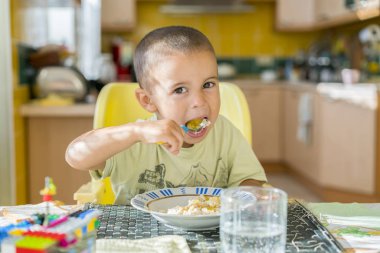 Çocuk 2 yıl püresi yiyor. Çocuk tablo. Childs'ın bağımsızlık kavramı. Yulaf lapası yemek mutlu küçük çocuk. Küçük çocuk masada kahvaltı