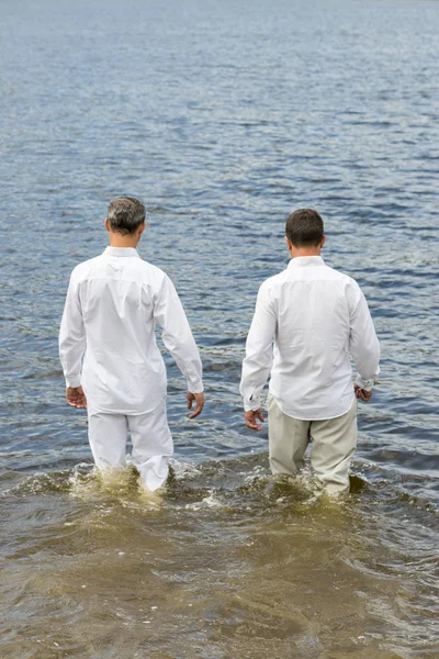 白い服の 人は海に入る 垂直写真 — ストック写真