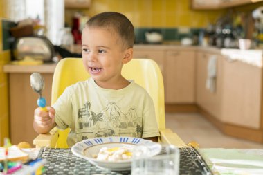 Yulaf lapası yemek mutlu küçük çocuk. Küçük çocuk masada kahvaltı.