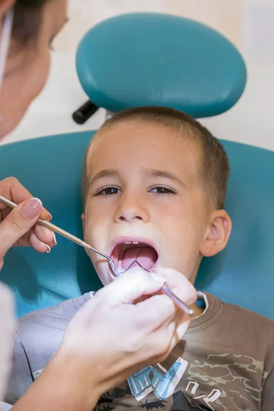 歯医者の少年 歯科医は 小さな男の子の歯を調べます 垂直写真 — ストック写真