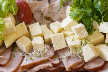 Soğuk etler peynir ile. Emmental peyniri ve İtalyan fırında Jambon dilimleri. Pastırma, peynir küpleri, salam, jambon ile tepsi.