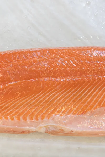スーパー マーケットのカウンターの上の氷にサケの切り身 スーパーで氷で赤魚の切り身 海洋健康食品 垂直写真 — ストック写真