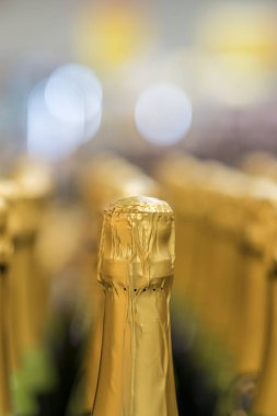 perspektif görünümü ayrıntı altın şampanya mağaza raf içinde düzenlenmiş Üstler şişe. Dikey fotoğraf