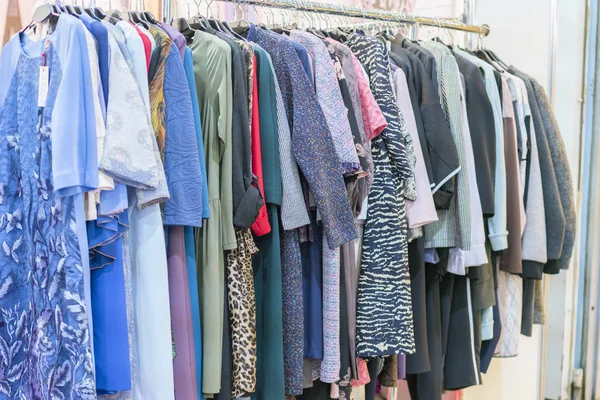 Bir perakende mağazası askı üzerinde renkli kadın kıyafetleri. Moda ve alışveriş kavramı. Askı Elbise deposuna.