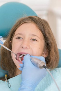 Açık ağız, diş hekimi ile genç çocuğun makro yakın çekim. Diş check-up dişçi ofisinde. Dişçi kız diş diş hekimleri sandalyede incelenmesi. dikey fotoğraf.