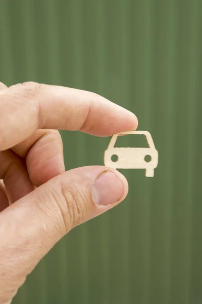 The hand keeps the car on a blurry green background. Car insurance. Man is holding car. my car. vertical photo.