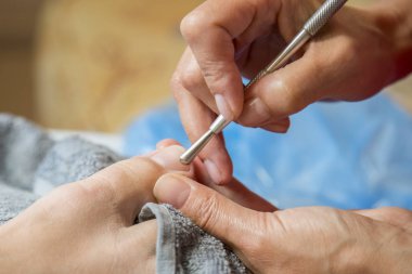 Pedikür yaparken profesyonel aletler kullanarak Master. Pedikür tedavisinde güzellik salonu. Kavram kapatın.