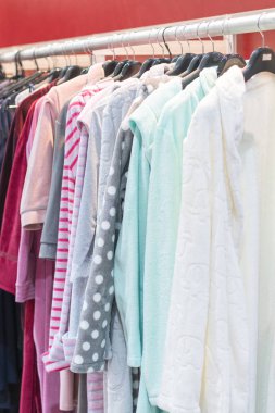 birçok bornoz herhangi bir renk. Raflar ve askılar pamuk ve bambu bornoz ile. Depodaki askı üzerinde gömlekler. dikey fotoğraf