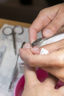 kalıcı makyaj imkanları. Uygulama, manikür makasla kesme manikür closeup. Süreç içinde güzellik salonu manikür, yakın çekim. dikey fotoğraf.