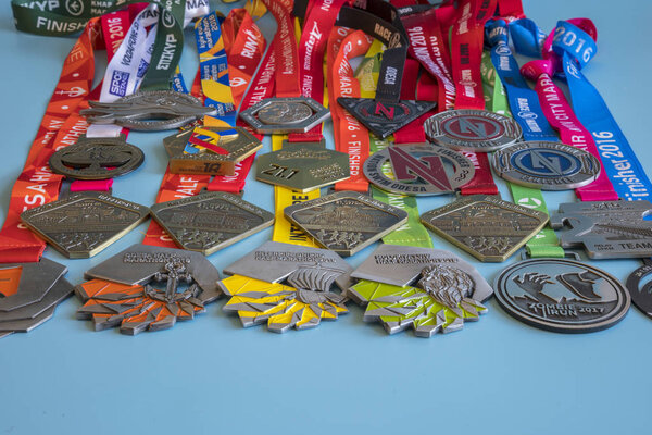 Киев, Украина. 2 сентября 2018 Много разных спортивных медалей на синем фоне. Медали за полумарафон, марафон и другие дистанции
.