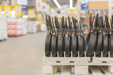 Depodaki bir satır tava yeni asılı. mutfak aletleri