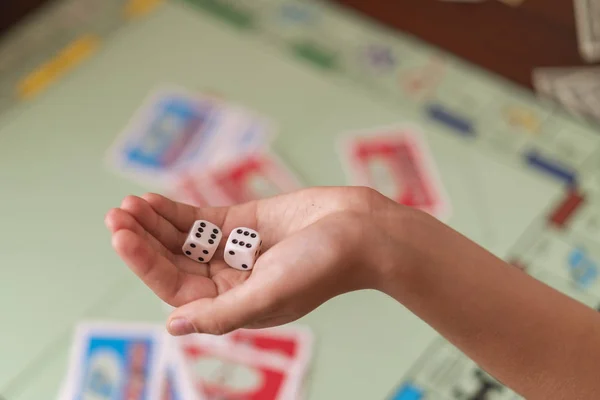 The hand throws game dice on the background of the playing field