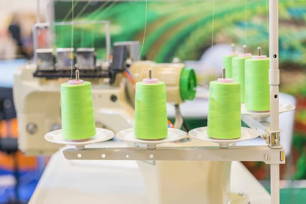 Закрытие профессиональной пишущей машинки для пошива одежды на фабрике. швейная машинка на размытом фоне. текстильная мастерская. Крупный план — стоковое фото