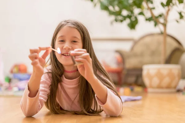 Girl playing with matches. Dangerous situation at home. A small child plays with matches, a fire, a fire flares up, danger, child and matches, lucifer match. — Stock Image Girl Playing Matches Dangerous Situation Home Small Child Plays Matches Royalty Free Stock Images