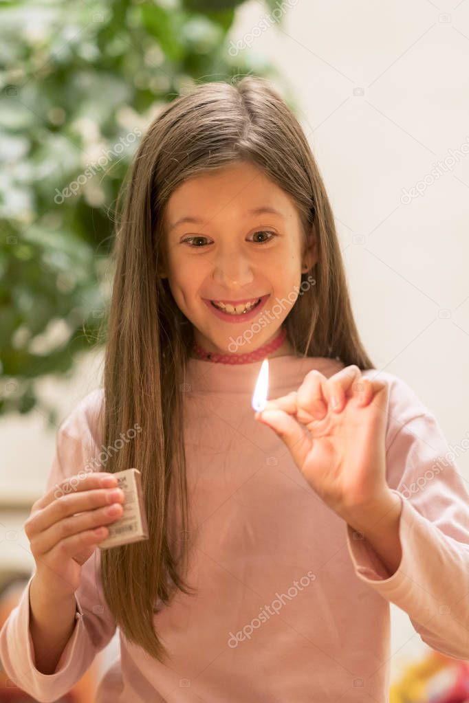 Girl playing with matches. Dangerous situation at home. A small child plays with matches, a fire, a fire flares up, danger, child and matches, lucifer match.
