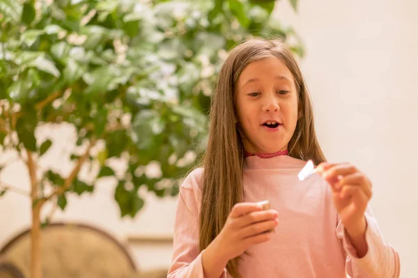 Girl playing with matches. Dangerous situation at home. A small child plays with matches, a fire, a fire flares up, danger, child and matches, lucifer match. — Stock Image Girl Playing Matches Dangerous Situation Home Small Child Plays Matches Royalty Free Stock Photos