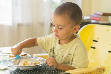 Çocuk 2 yıl püresi yiyor. Çocuk tablo. Çocuğun bağımsızlık kavramı. Yulaf lapası yemek mutlu küçük çocuk. Küçük çocuk masada kahvaltı.