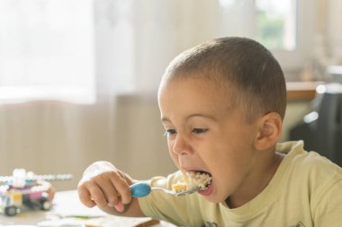 Çocuk 2 yıl püresi yiyor. Çocuk tablo. Çocuğun bağımsızlık kavramı. Yulaf lapası yemek mutlu küçük çocuk. Küçük çocuk masada kahvaltı.