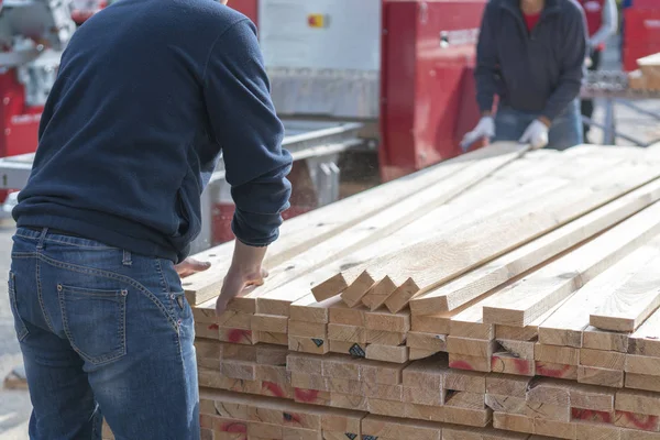 Bir adam bir kereste fabrikası çalışıyor. Adam panoları katlama