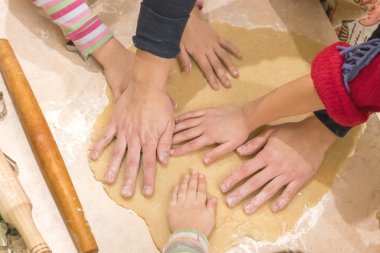Bebek eller bisküvi yemek için dışarı hamur rulo. Takım çalışması ve dostluk kavramı.