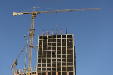 Yüksek katlı bina inşaatı. Crane, inşaatçılar mavi gökyüzü.