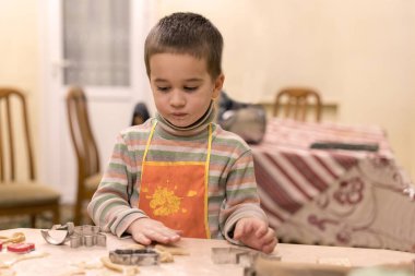 küçük çocuk turuncu önlük kurabiye hamur kalıplama 4 yaşında.