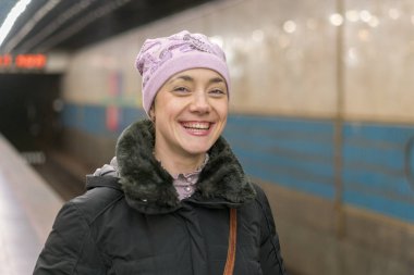 mutlu kız Metro platformda ayakta.