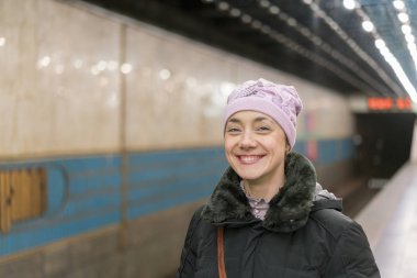 Tren İstasyonu peronne adlı için bekleyen genç gülen kız.