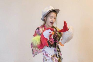 8 yıl içinde kukla tiyatro oynarken şapkalı bir kız. Hafif bir arka plan karşı. kopya alanı