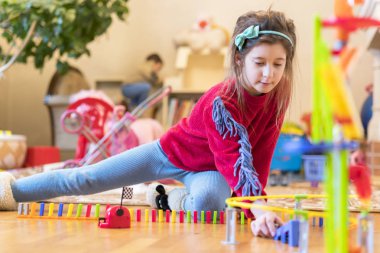 Kız 8 yaşında oyuncaklar ile odada oynanır.