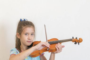 Sevimli öğrenci ilköğretim okulunda sınıfta keman çalıyor. Keman çalmaya kız.