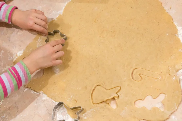 The child makes pastry with dough from forms.