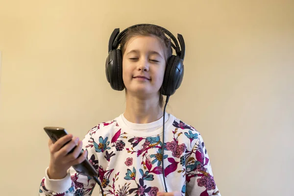 Mała Dziewczynka Słuchawki Przy Użyciu Telefonu Uśmiechnięta Dziewczynka Smartphone — Zdjęcie stockowe