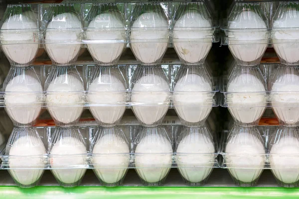 White eggs in transparent trays.