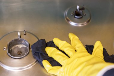 Gaz sobası koruyucu eldiven bir kadında yıkıyor.