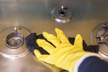 Gaz sobası koruyucu eldiven bir kadında yıkıyor