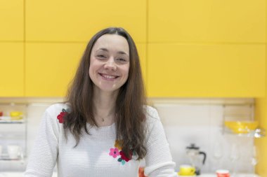 Yeni modern bir mutfak mutlu bir genç kadın. Mutlu genç kadın uzun saçlı.