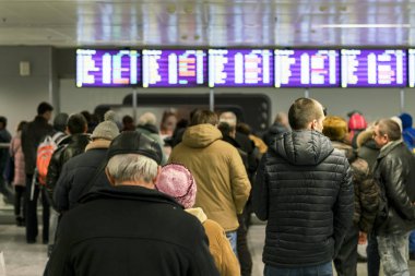 İnsanlar havaalanında uçuş varış için bekliyor. Seçilen odak.