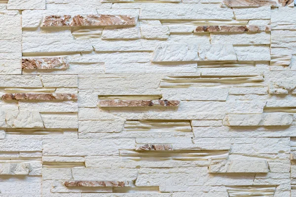 Wall made of decorative light brown stone. Decorating for the fireplace. Background.