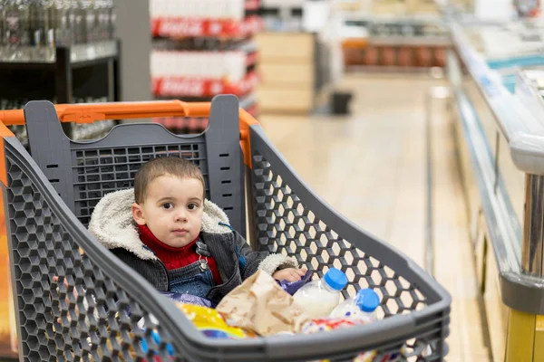Полная Тележка Едой Супермаркете Тележке Сидит Ребенок — стоковое фото