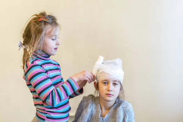 Duas Raparigas Brincam Aos Médicos Bandage Sua Cabeça Com Uma — Fotografia de Stock