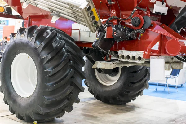 Part of an agricultural machine with large wheels.