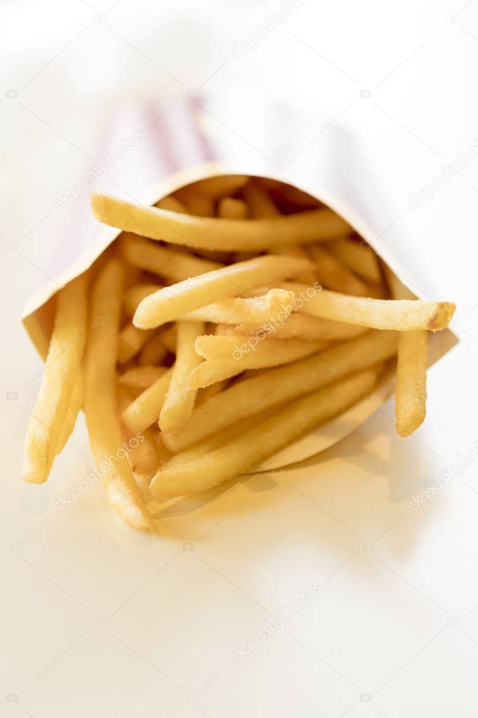 French fries in a box on a light background. Unhealthy food. Delicious food.