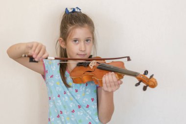 Sevimli öğrenci ilköğretim okulunda sınıfta keman çalıyor. Keman çalmaya kız.